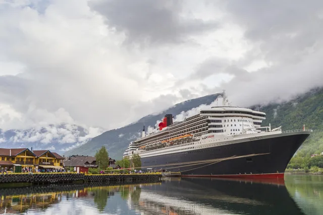 Illustrative ocean liner beside a mountain harbor