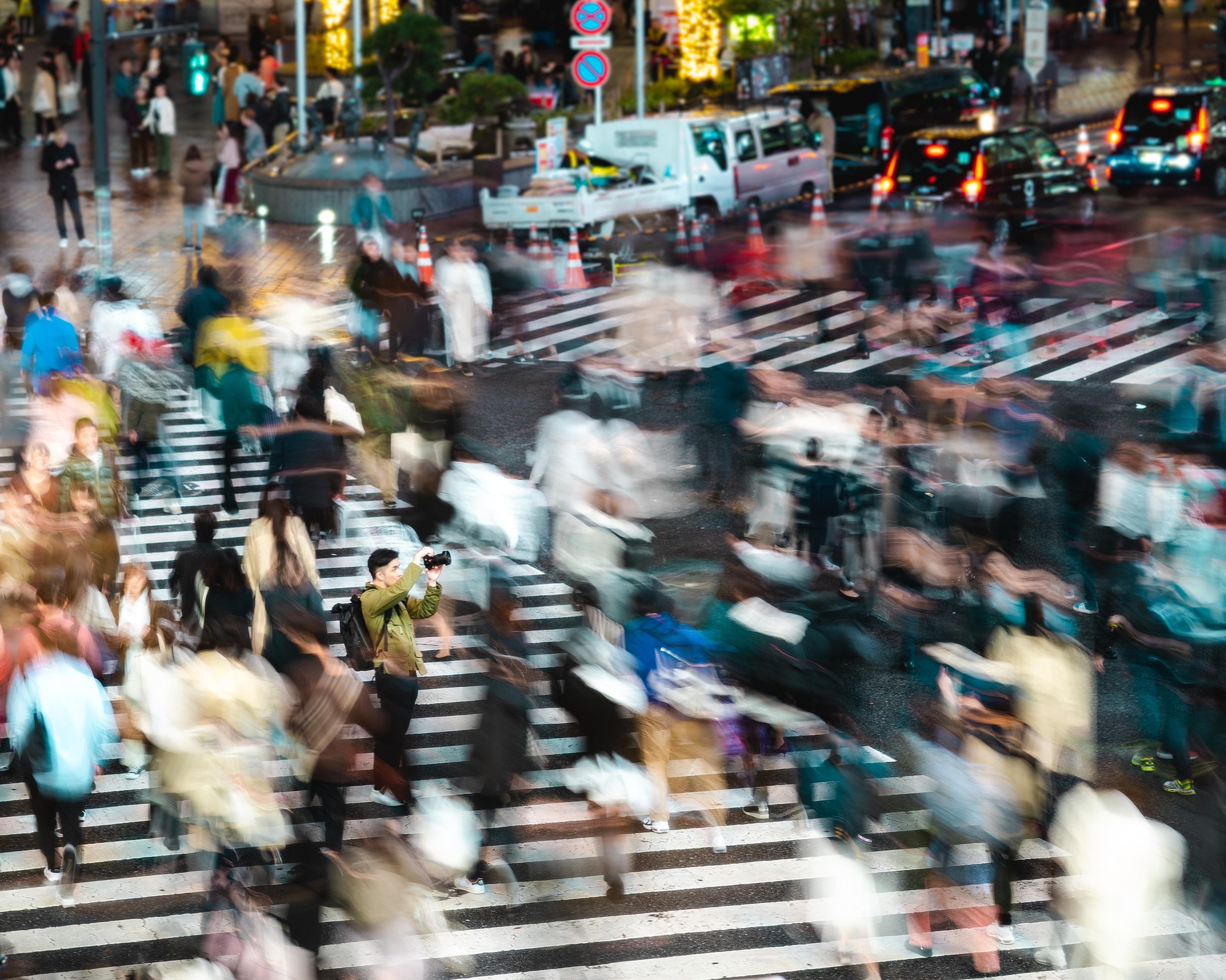 Pedestrians moving across Shibuya Scramble Crossing in the evening