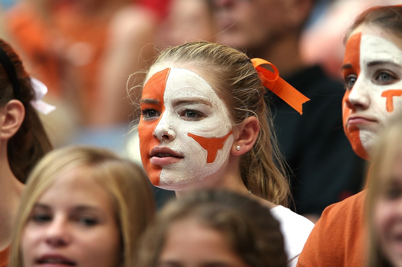 College football fans in orange cheering from the stands