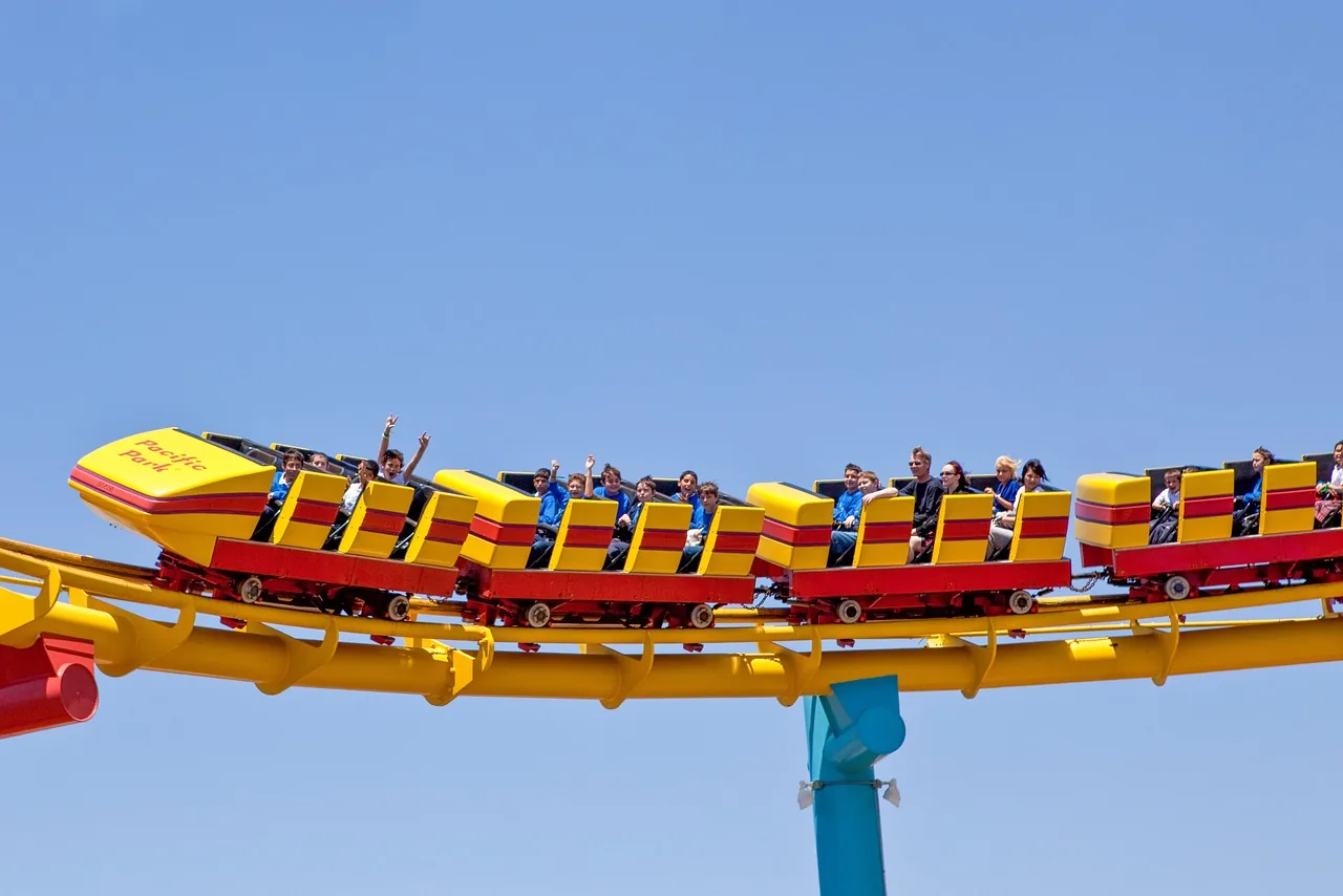 Yellow roller-coaster track and red ride supports at Pacific Park on Santa Monica Pier