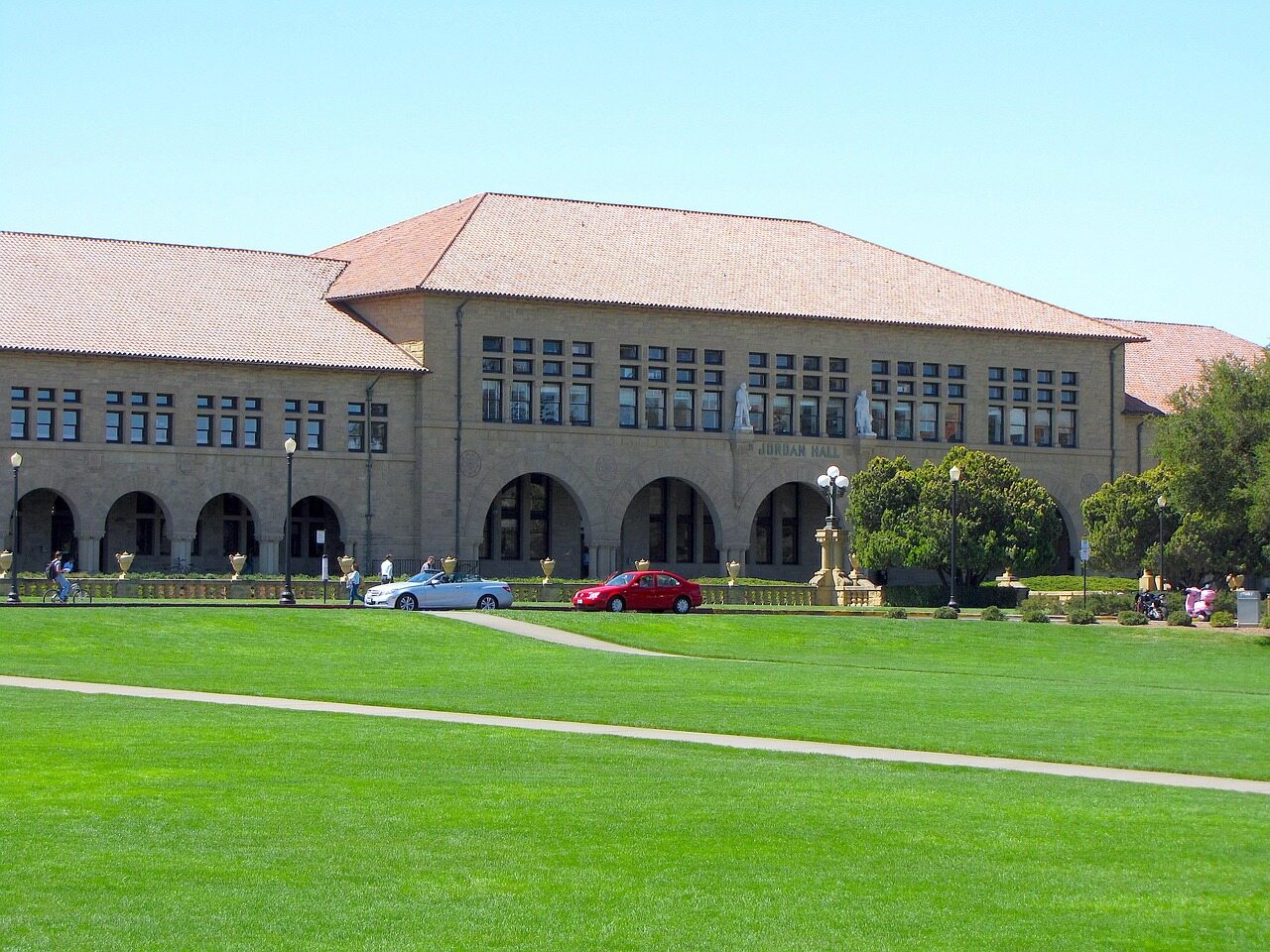 Stanford University campus building with a tiled roof and a green lawn